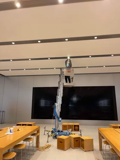 Electrician installing downlights from boom lift